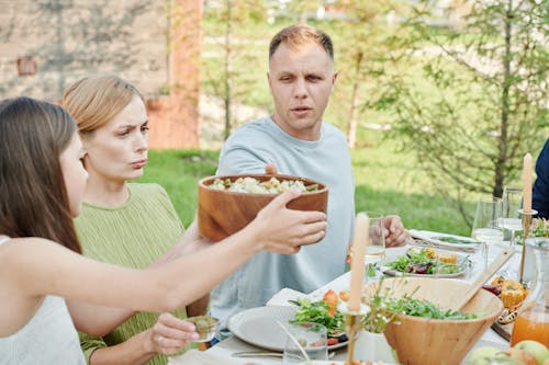 Free Kid Passing a Bowl of Salad Stock Photo