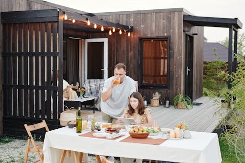 Man Standing Beside the Woman Sitting at Table 