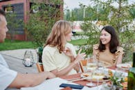 Woman in White Long Sleeve Shirt Sitting Beside Woman in White Long Sleeve Shirt