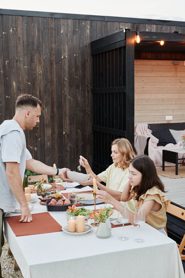 A Family Having Dinner In The Backyard