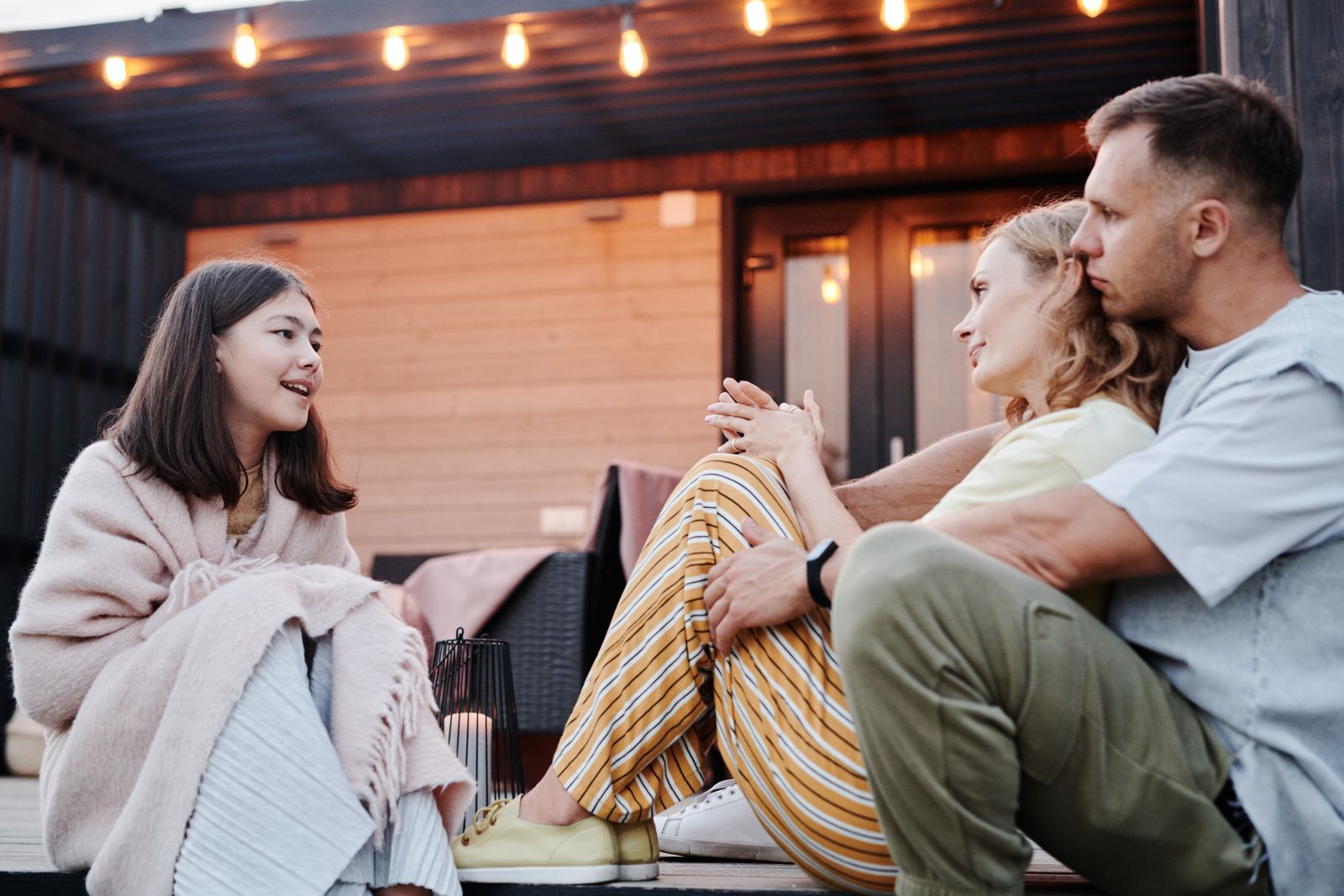Key art for The Fairbanks: a family talking on a lamplit porch at dusk. Photo by Julia M Cameron on Pexels