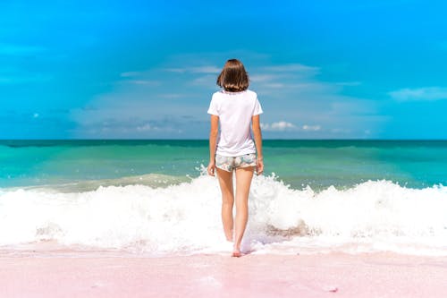 Free Woman Standing on Seashore Stock Photo