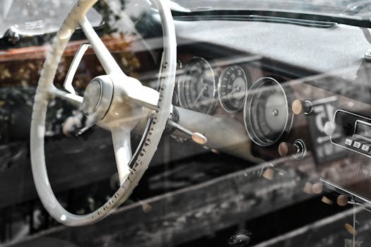 Close-up of a vintage car's dashboard and steering wheel, showcasing classic design.