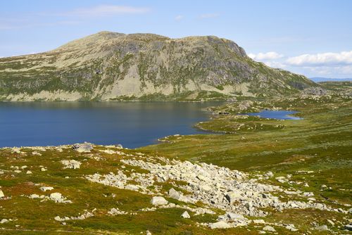 Free Tranquil mountain lake surrounded by lush green hills under a clear blue sky, perfect for nature lovers. Stock Photo