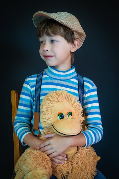 Boy in Blue Long Sleeve Shirt Holding a Stuffed Toy