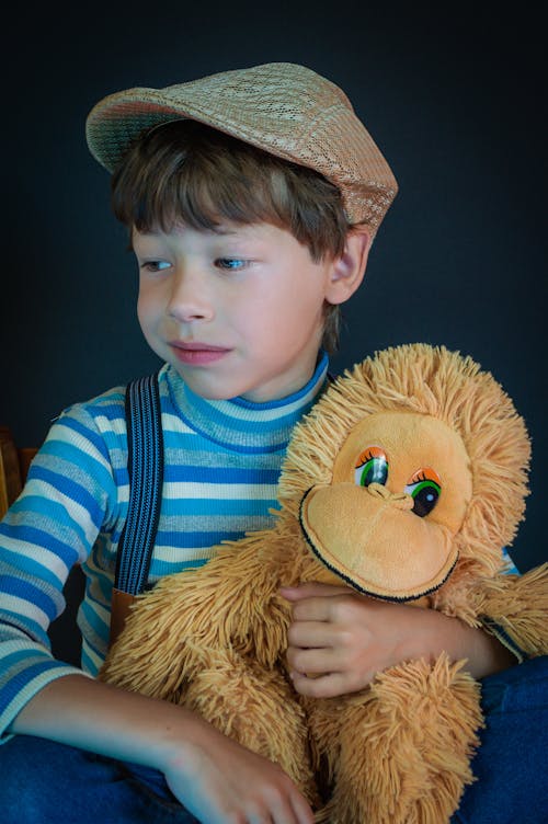 Close Up Photo of Boy Holding a Plush Toy