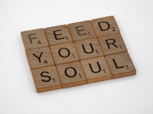 Free Close-up of Scrabble tiles spelling 'Feed Your Soul' on a white background. Stock Photo