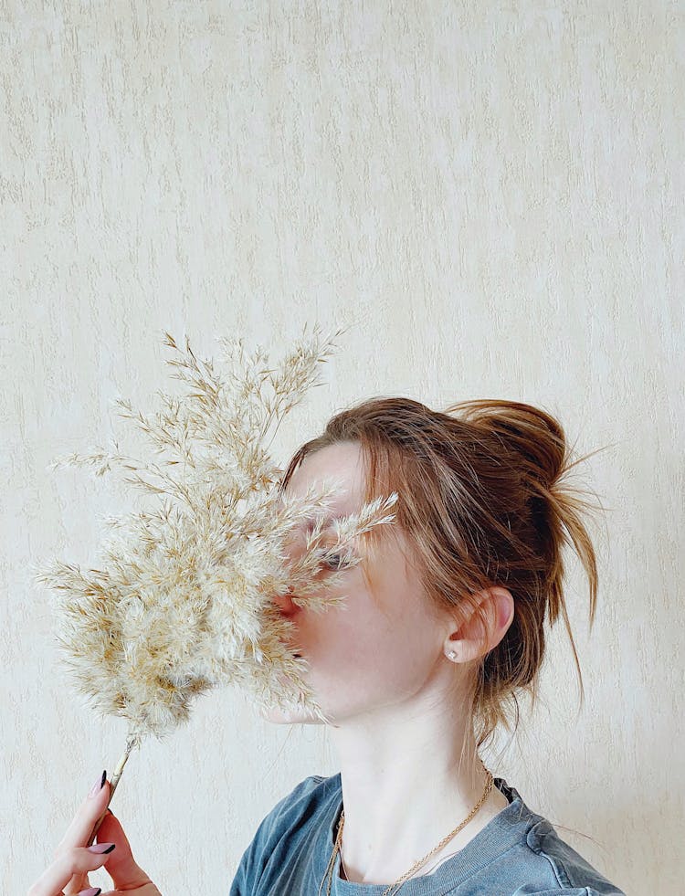 Portrait Of Woman Hiding Face Behind Dried Grass