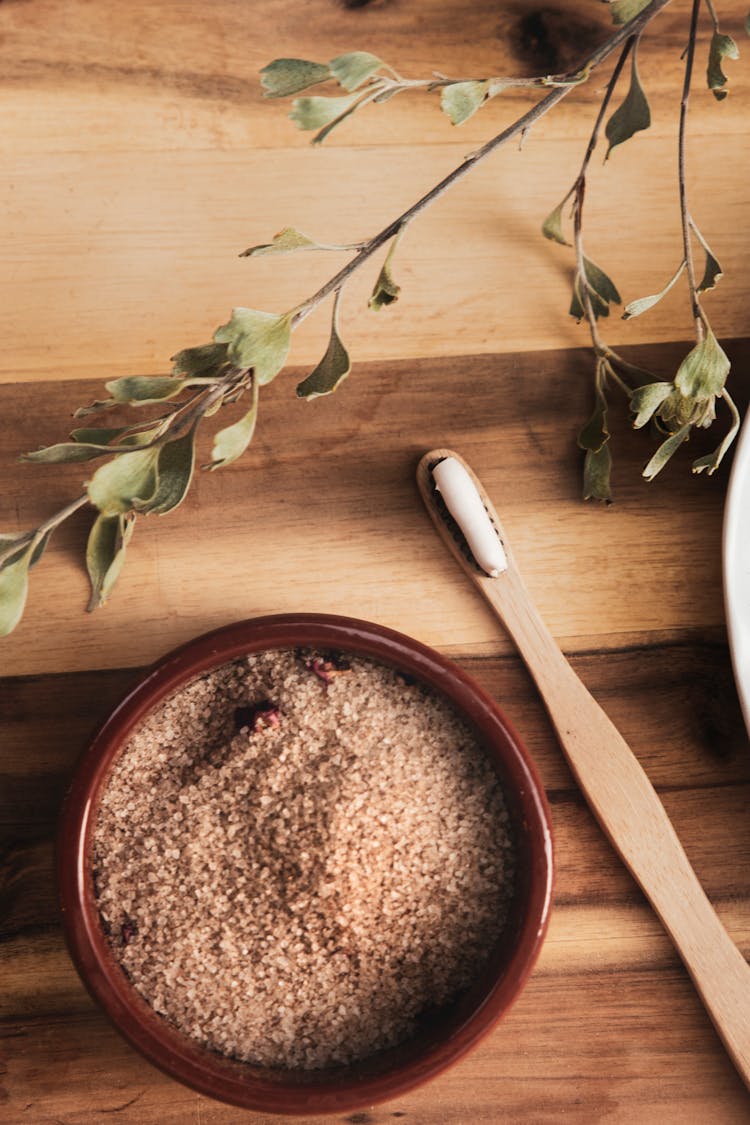 Wooden Toothbrush Beside A Bowl With Brown Powder