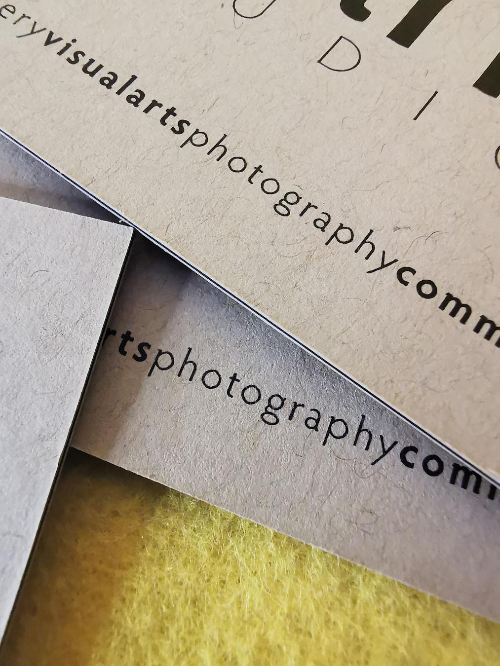 Textured paper business cards showcasing graphic design and typography.