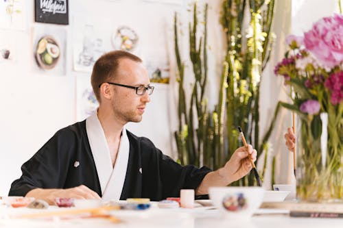 Man Painting in Workshop with Traditional Asian Technique