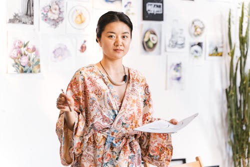 A Woman in a Printed Kimono Holding a Drawing