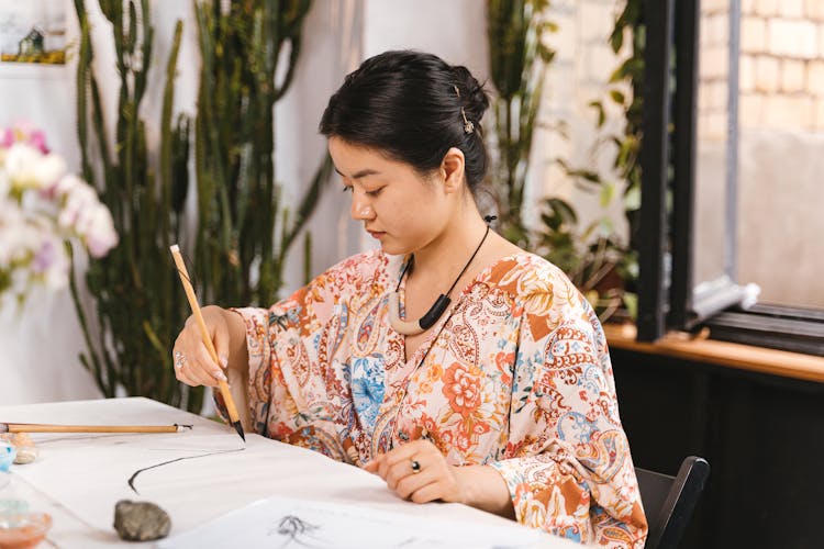 Woman Practicing Calligraphy With Brush