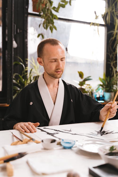 A Person wearing Robe doing Painting 