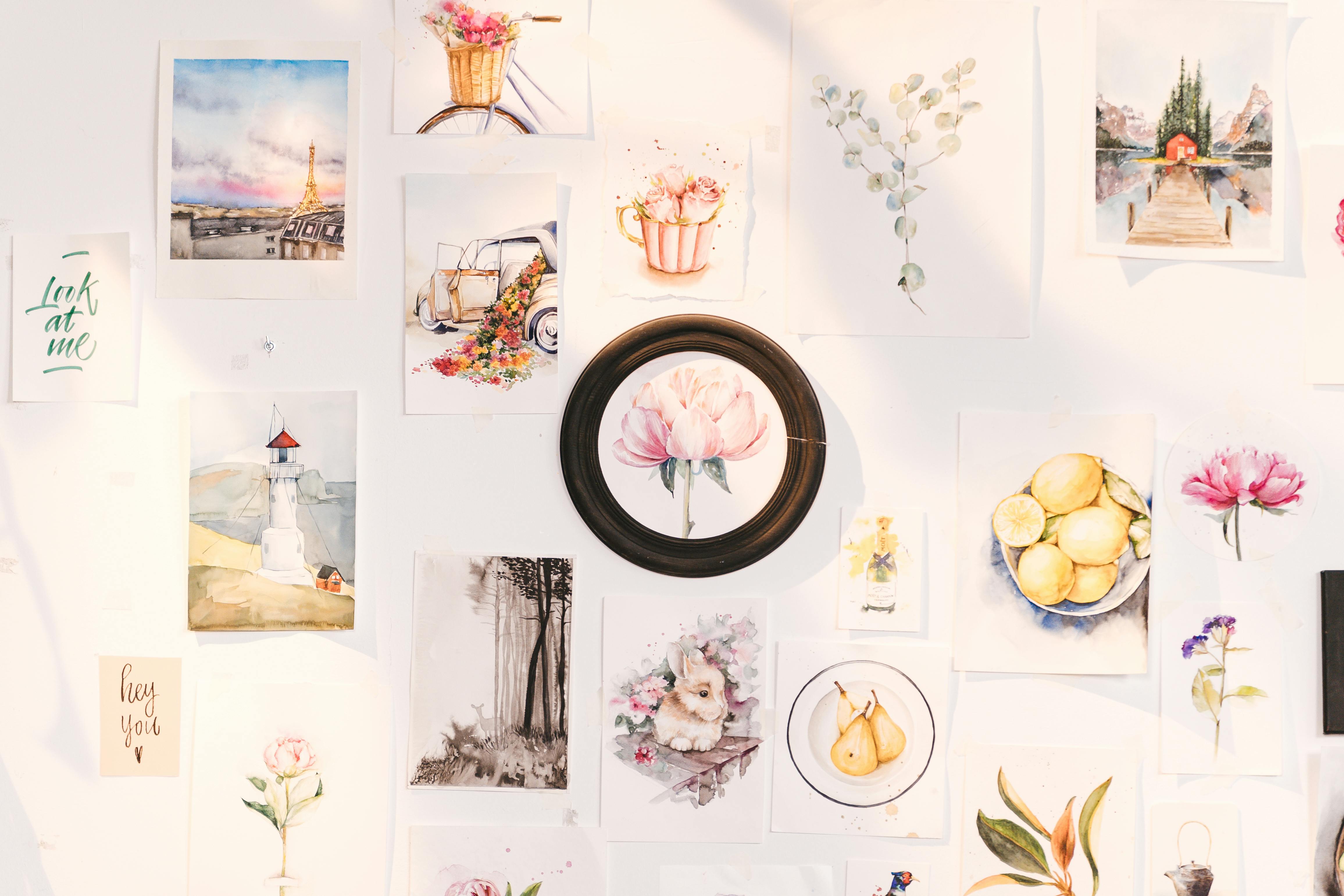 A vibrant collection of art prints showcasing flowers, landscapes, and creative designs on a wall.