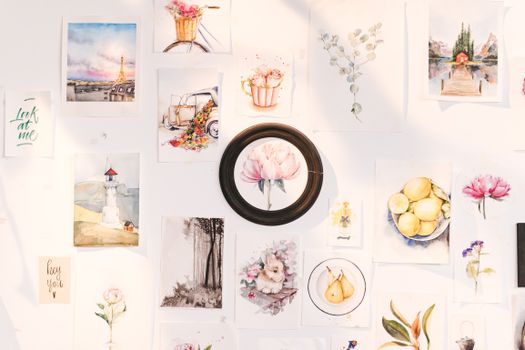 A vibrant collection of art prints showcasing flowers, landscapes, and creative designs on a wall.