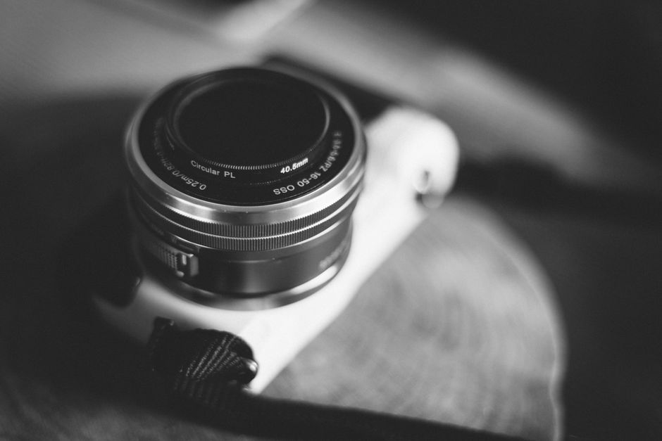 Close-up of a vintage camera lens showing intricate details in black and white