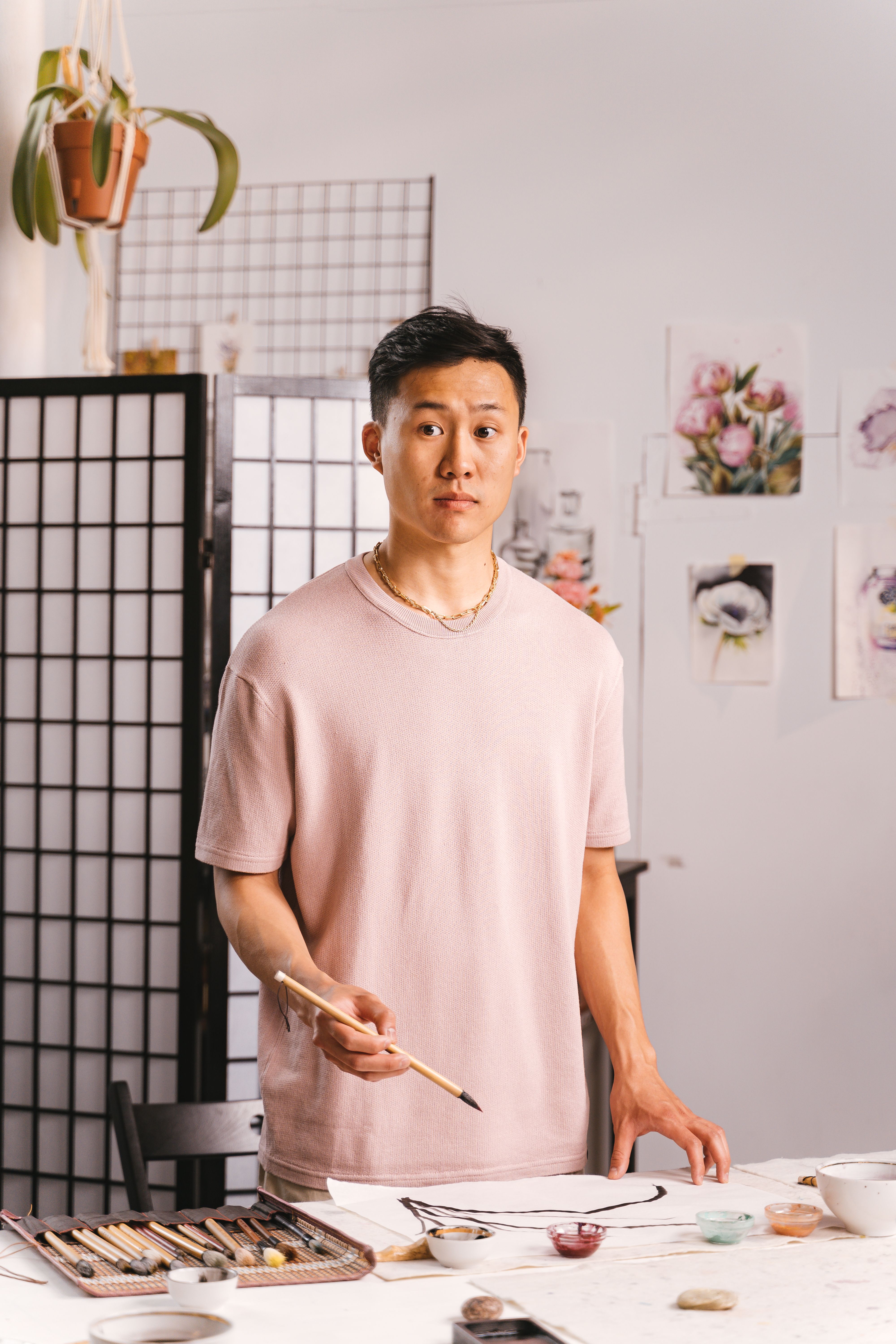 Young artist painting in a modern studio surrounded by floral art.