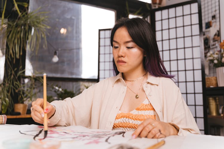 Focused Woman Drawing On Paper