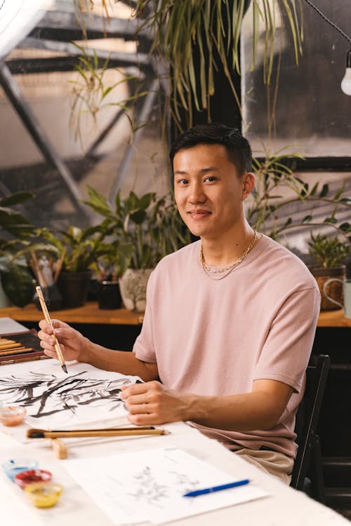 Man Wearing a Beige Shirt Holding a Paintbrush