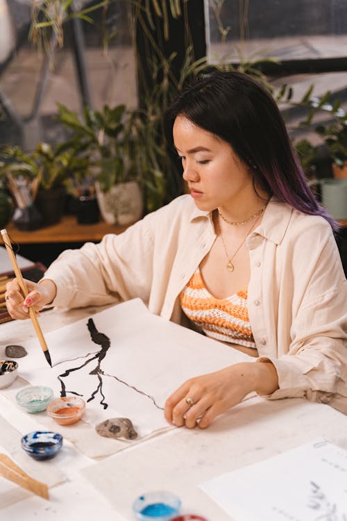 Woman Sitting while Painting an Art