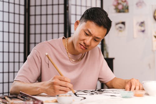 Woman in Pink Crew Neck T-shirt Holding Pencil