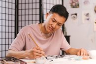 Woman in Pink Crew Neck T-shirt Holding Pencil