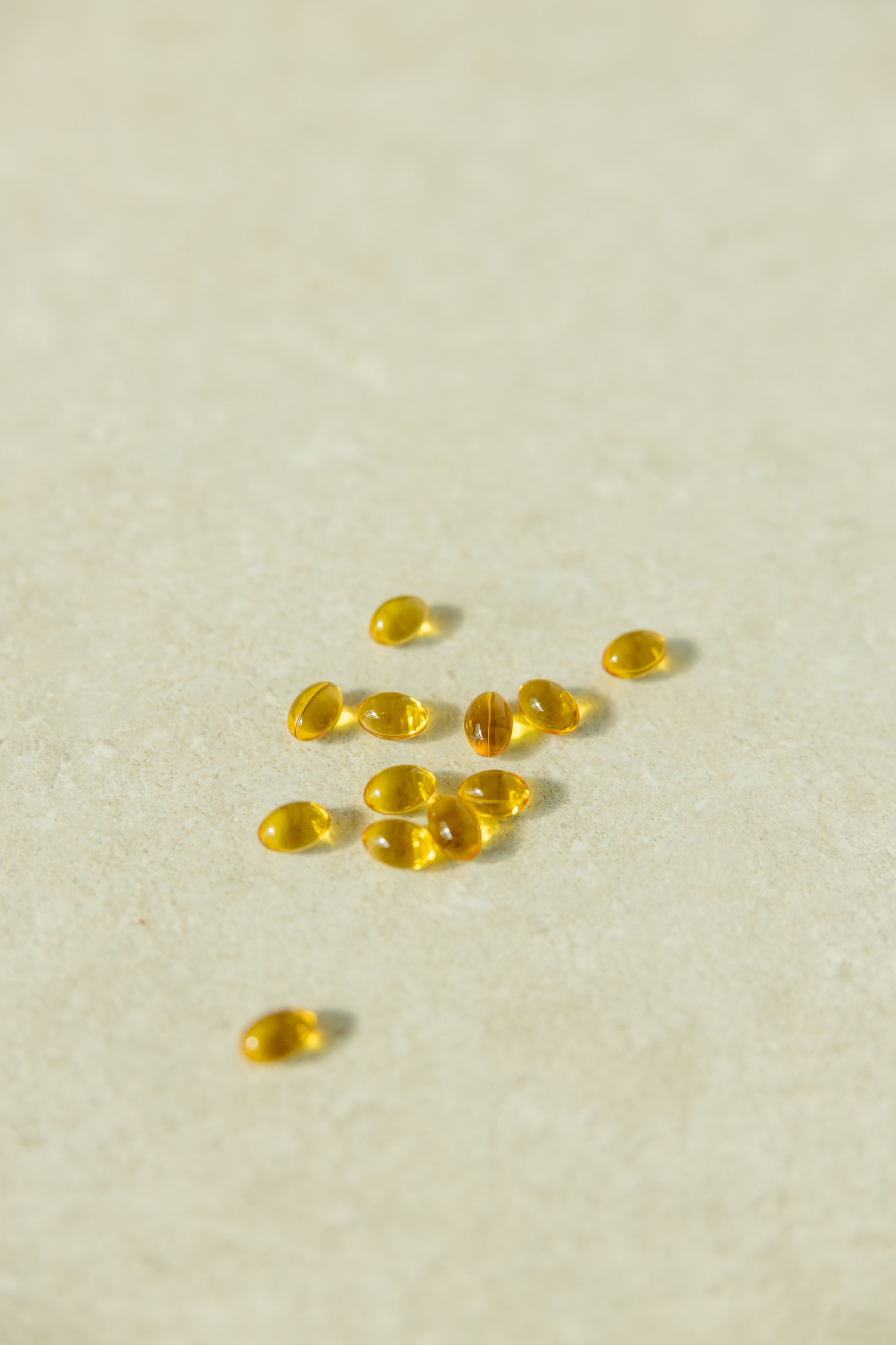 Golden supplement capsules on clean light background