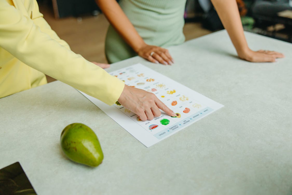 Free Person in Green Shirt Holding White Printer Paper Stock Photo