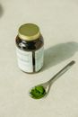 White Labeled Bottle Beside Silver Spoon