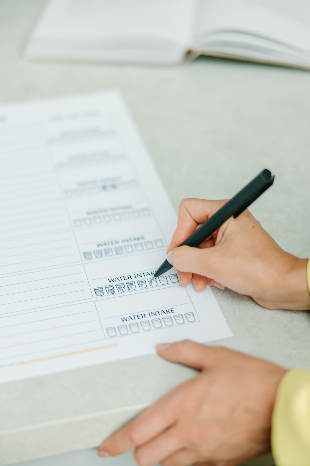 Aesthetic Digital Planner | Daily, Weekly & Monthly Planner Hands filling out a nutrition plan with a focus on water intake tracking