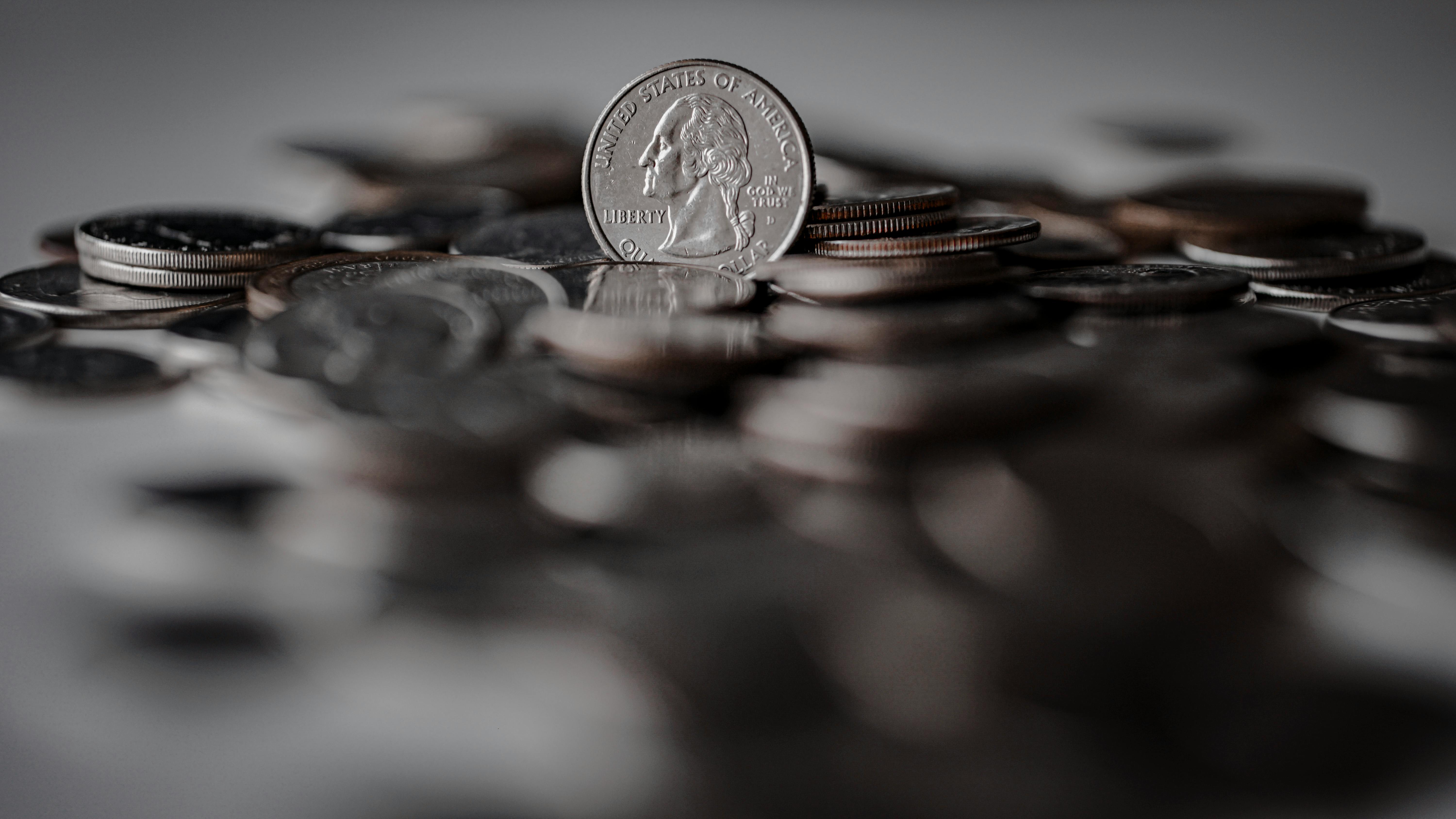 silver round coins on brown wooden surface