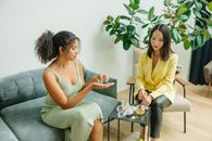 Woman in Yellow Sleeveless Dress Sitting on Chair Beside Woman in Yellow Sleeveless Dress