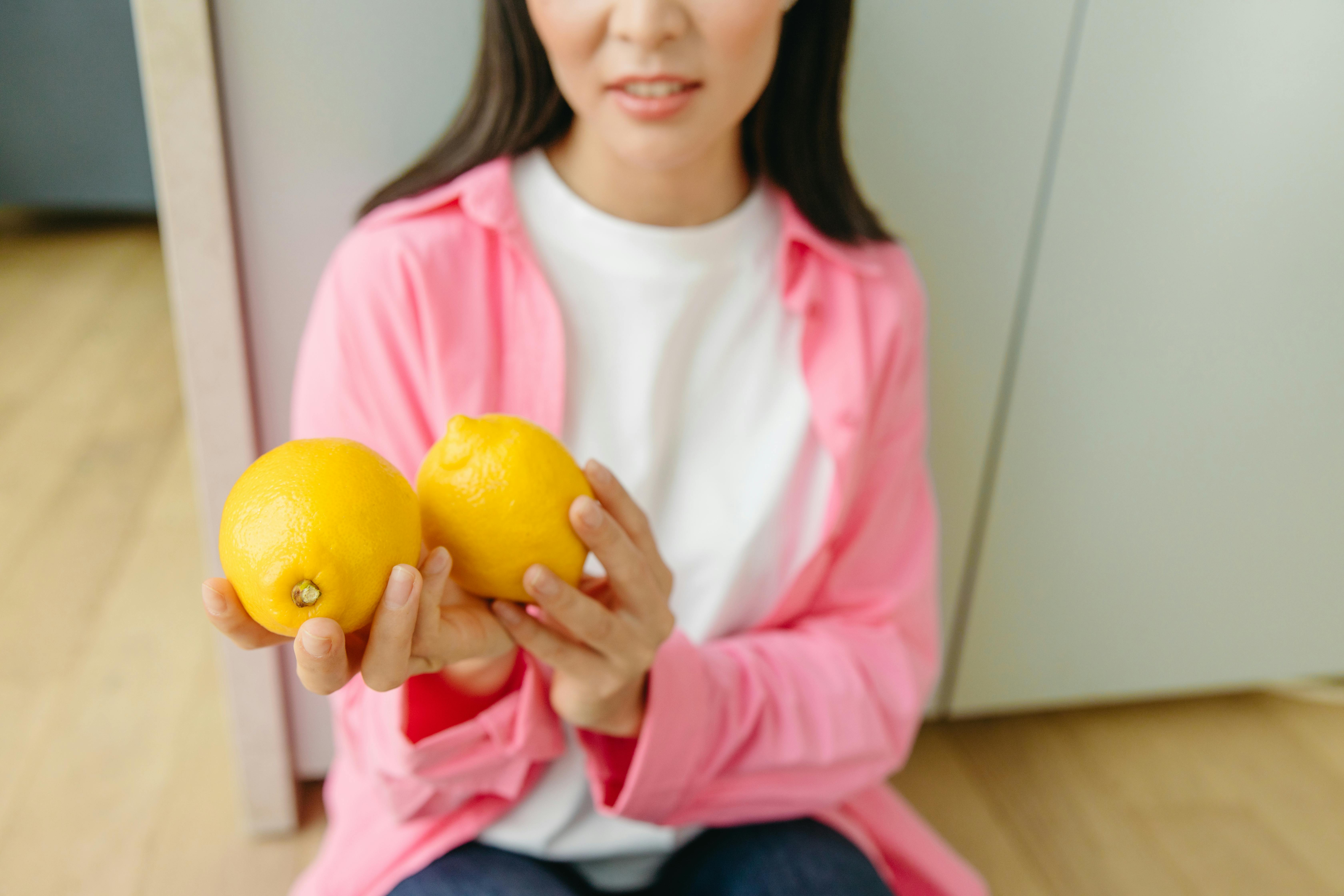 a woman holding yellow lemons