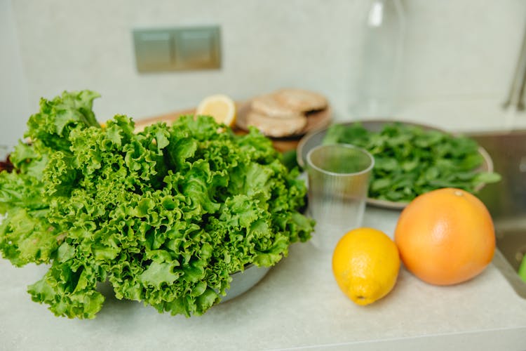 Fresh Salad And Citrus Fruits On Table