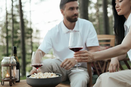Free A Couple Having Wine and Popcorn in the Forest Stock Photo