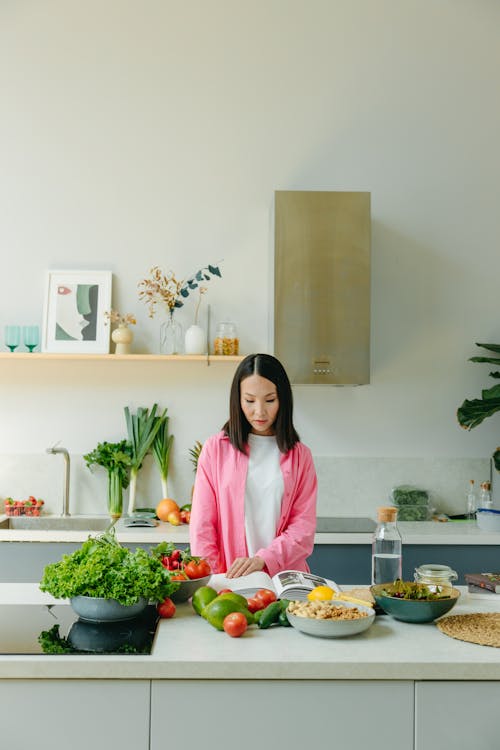 Free A Woman Reading a Book in the Kitchen Stock Photo