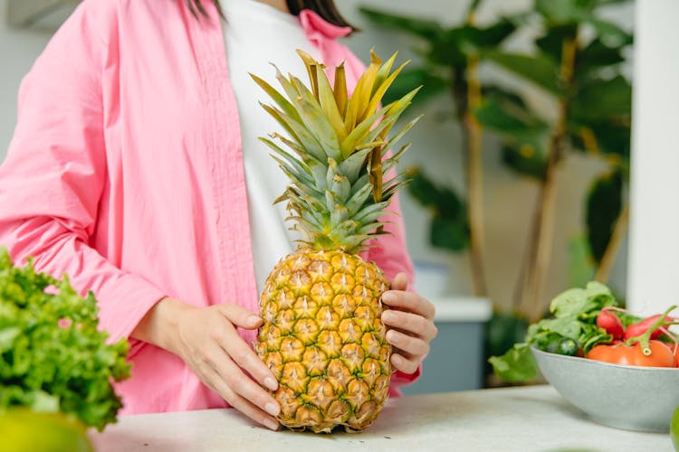 A Woman Holding A Pineapple