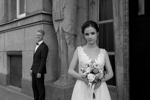 Grayscale Photo of Woman Holding Bouquet of Flowers