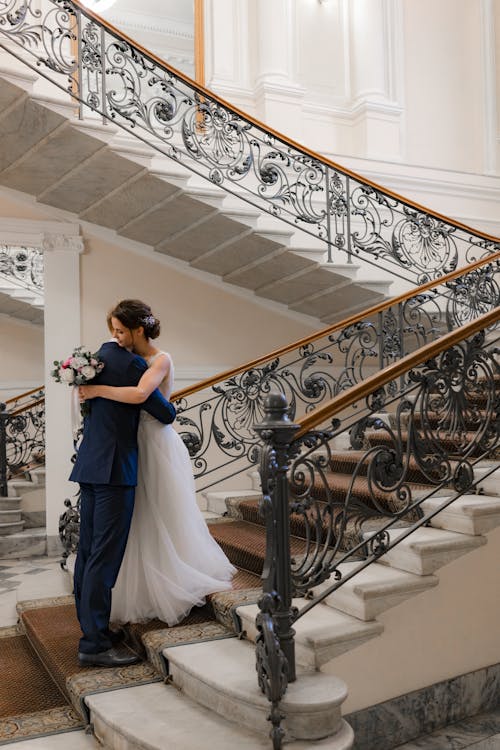 A Bride and Groom Hugging in the Staircase