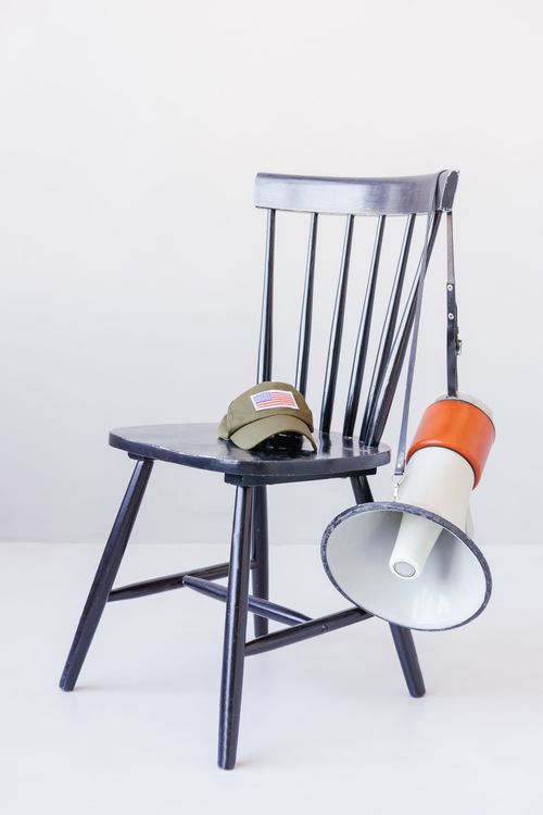 Free Wooden chair with cap and megaphone representing communication and patriotism. Stock Photo