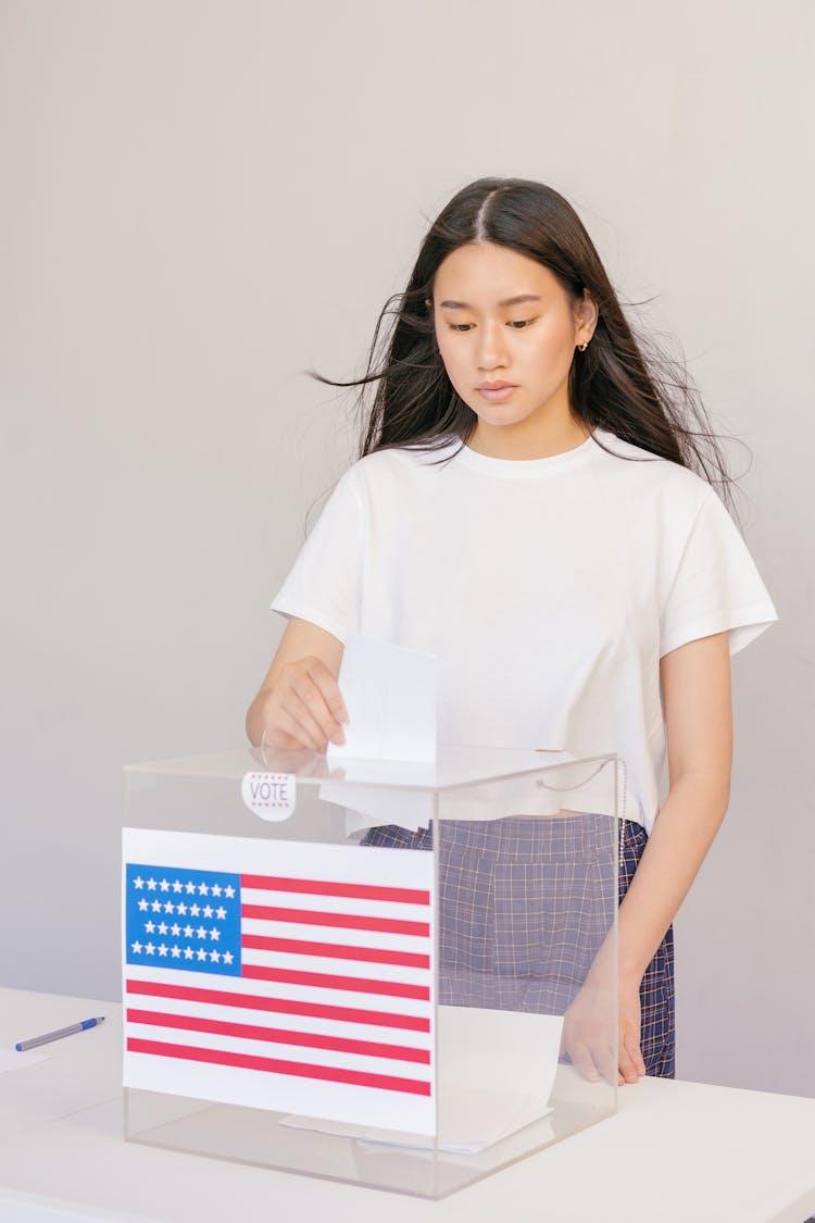 Woman Putting Her Vote On Ballot Box