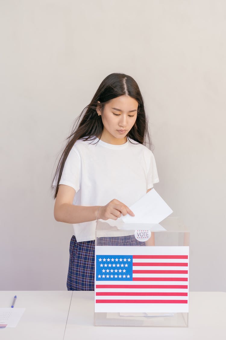 Woman Putting Her Vote On Ballot Box