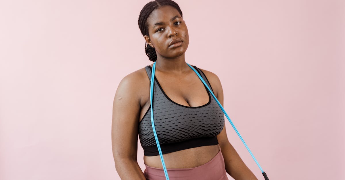 Young woman in stylish activewear using a resistance band during a workout session.