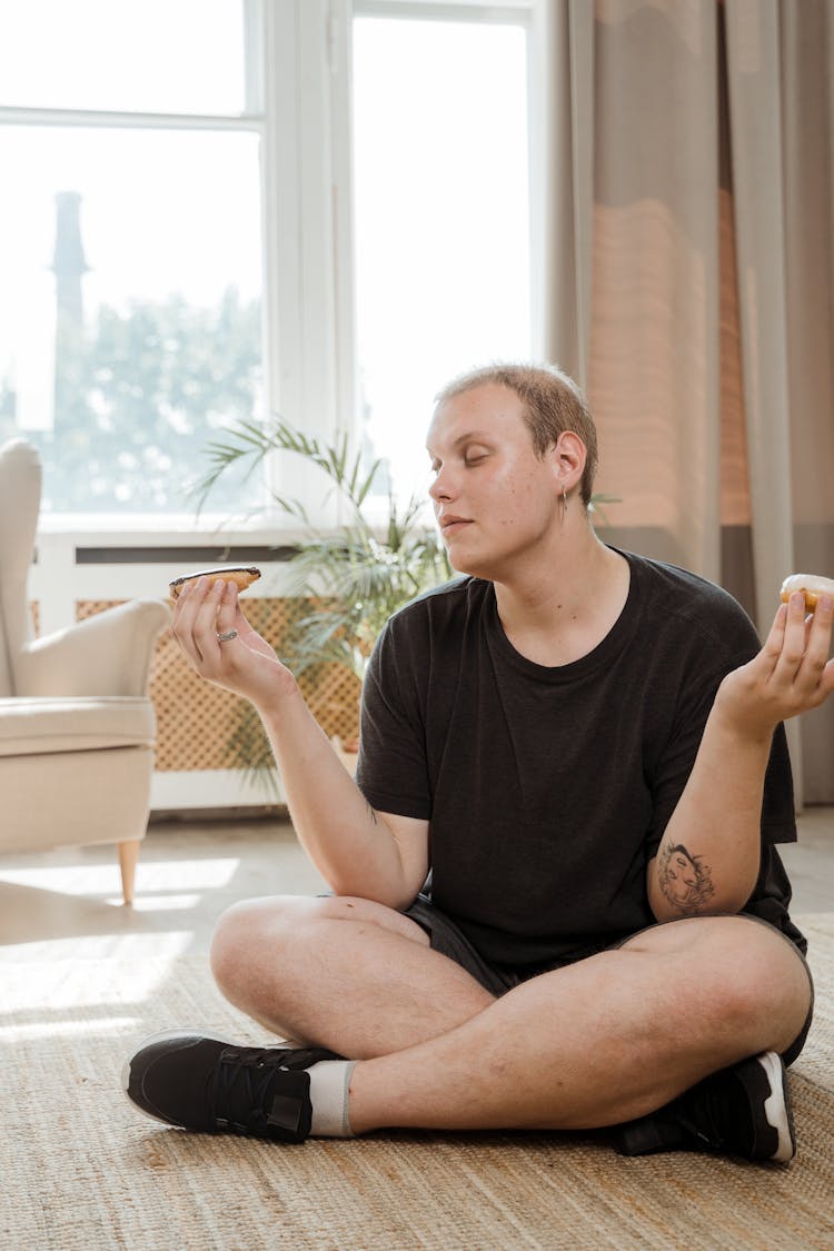 Man Holding Donuts In Both Hands