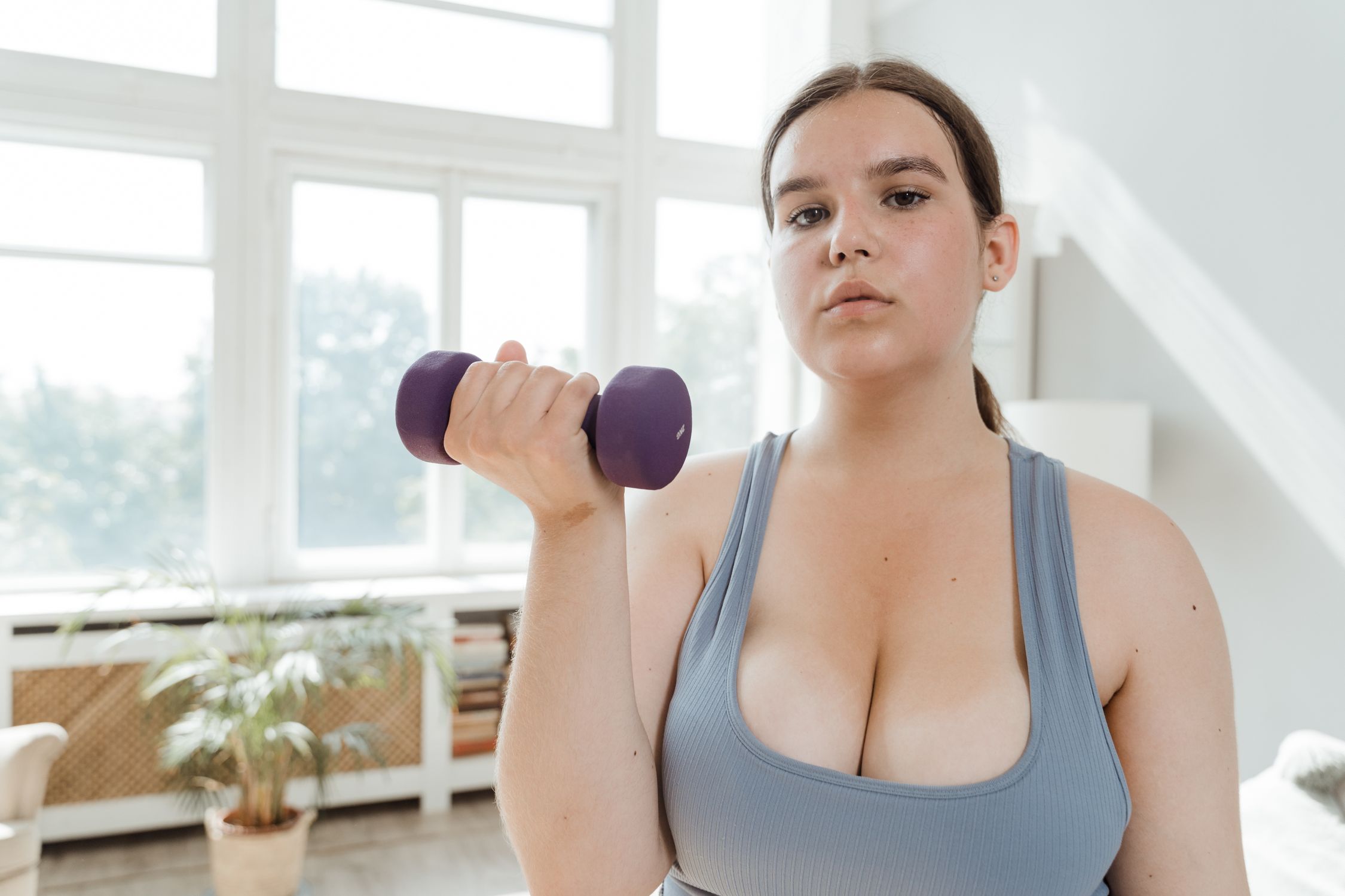 Mulher jovem praticando exercício físico intenso, demonstrando que a musculação é para todas as idades.