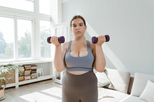 Photograph of a Woman Lifting Purple Dumbbells