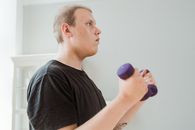 Man in Black Crew Neck T-shirt Holding Purple Dumbbell