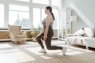 A Woman Doing Lunges while Holding a Dumbbell