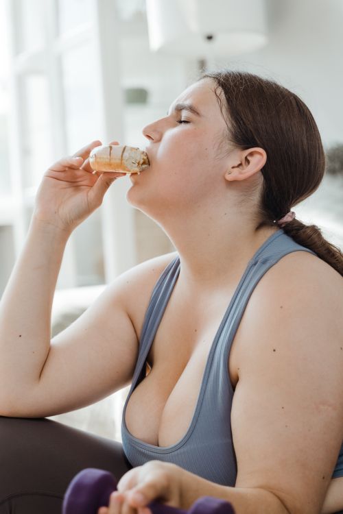 Free A woman in activewear takes a break with ice cream, highlighting balance in fitness and indulgence. Stock Photo